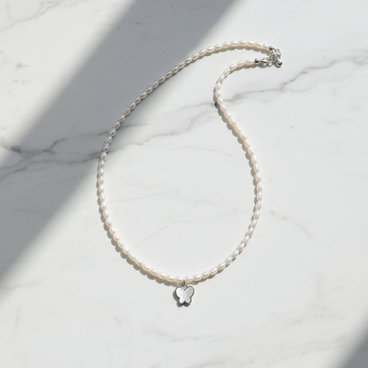 Pearl Butterfly Necklace on white marble surface