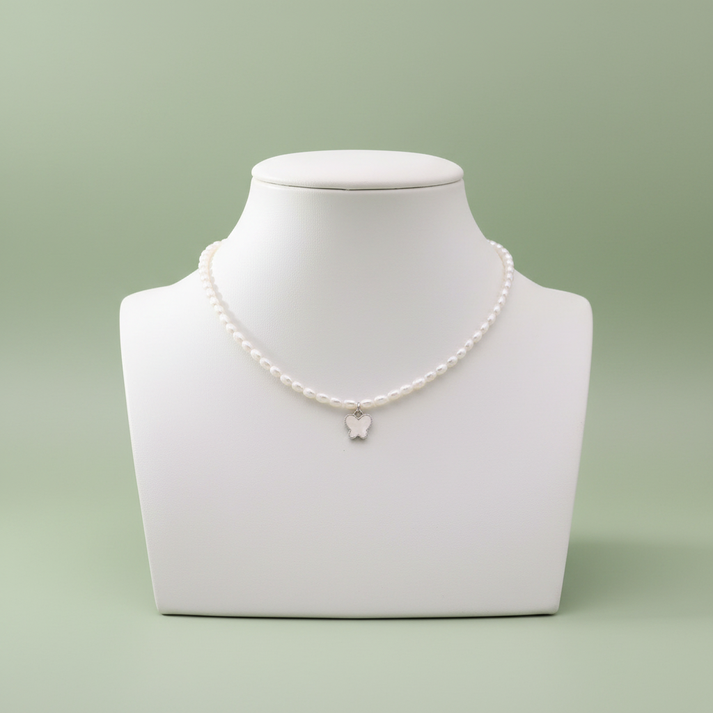 Pearl Butterfly Necklace on ceramic bust sage green background